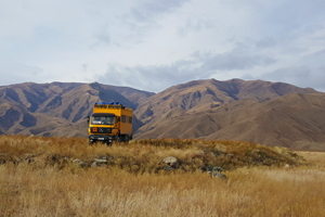 High atop the yellow wagon through Kyrgyzstan