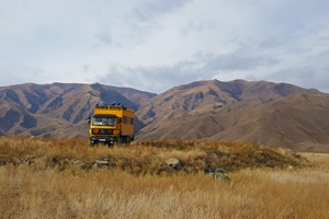 High atop the yellow wagon through Kyrgyzstan