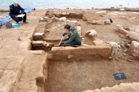Menschen messen die ausgegrabenen Gebäude aus